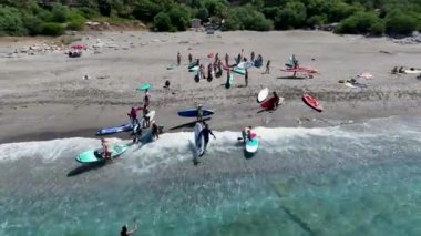 Yaz ayının ilk günü sakin körfezdeki bir SUP festivalinde kürek çeken ve eğlenen arkadaşları görün..