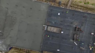 İnşaat halindeki büyük bir binanın temellerine beton döken işçilere bakın.