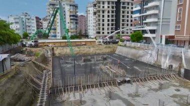 Temelin üzerine beton dökülüp yeni bir inşaat projesi için temel oluşturulmasını izle..