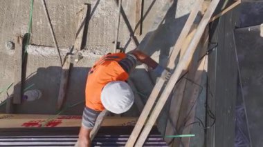 Çalışan inşaat işçilerinin yoğun bir inşaat alanında yük taşıyıcı duvarlar inşa edişini izleyin..