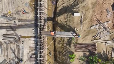 Yeni bir bina için zemin ve duvarlar inşa eden inşaat işçilerine dikkat edin..