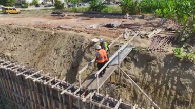 İnşaat işçilerinin bir bina için temel yük duvarları ve zemin inşa ettiklerini gözlemleyin..