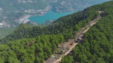 Yeşil ormanlar ve geniş açık alanlarla çevrili bulut kaplı dağların tadını çıkarın..