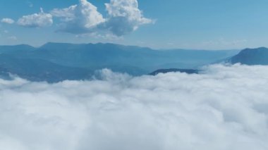 Yeşil ormanları ve açık çayırları olan bulutlu dağ tepelerinin çarpıcı manzarasına bakın..