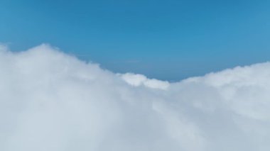 Yeşil ormanlar ve geniş manzara manzaralarıyla çevrili bulutlu dağlara bakın..