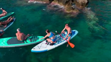 Akdeniz 'in sakin, mavi sularında güzel bir kürek tahtası yolculuğu izleyin..