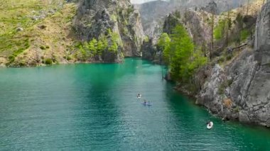 Türkiye 'nin büyük kanyonunda bir grubun doğayı keşfettiği manzaralı kürek çekme macerasını izleyin.