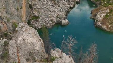 Manzaralı yeşil bir kanyonda kürek çeken gruba bakın, doğanın güzelliğini keşfediyorlar..