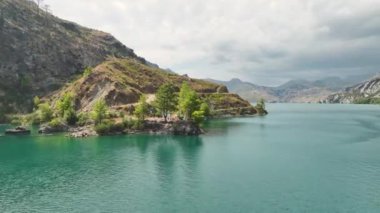 Bir kanyonun yeşil manzarasında süzülen sörfçülere bakın..