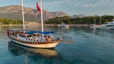 Güneş doğarken Antalya Kemer 'in sakin sahil şeridini seyret, berrak sular ve yatlarla..