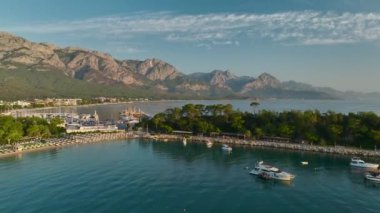 Şafak vakti Antalya Kemer 'in çarpıcı gezinti alanı boyunca uzanan huzurlu yat ve altın plajların tadını çıkarın..