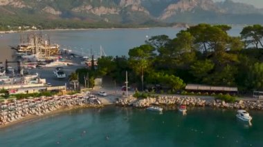 Antalya Kemer güvertesi boyunca altın plajları olan deniz ve marinada gün doğumunda gezinen yatları görün..