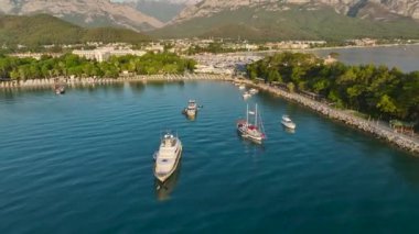 Güzel Antalya Kemer gezinti güvertesinde güneş doğarken altın plajlara ve huzurlu yatlara bakın..
