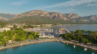 Antalya Kemer 'in sahil şeridinde şafak sökerken sakin yatları ve altın plajları görün..