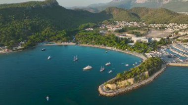 Antalya Kemer 'in üzerinde sakin gündoğumunun tadını çıkarın, yat limanında ve sahil boyunca uzanan altın plajlarla..