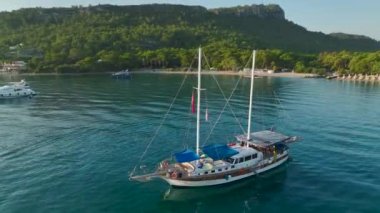 Antalya Kemer 'in altın plajları üzerinde gün doğumunu izleyin, yat ve deniz kıyılarında demirli..