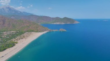 Akdeniz 'in ışıl ışıl mavi sularıyla Antalya' daki geniş plajın tadını çıkar..