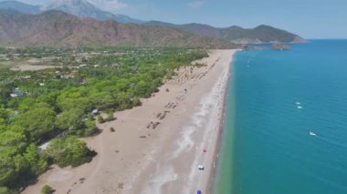 Akdeniz 'in berrak mavi sularıyla Antalya' daki geniş, yumuşak kumlu sahile bakın..