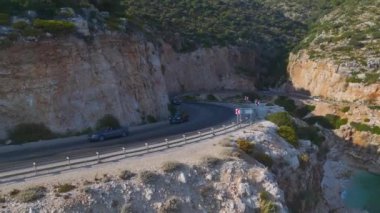 Akdeniz manzarası nefes kesici olan üstü açık bir yolculuğa çıkan bir çift görüyorum..