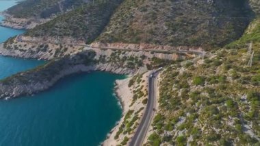 Üstü açık bir arabada, Akdeniz 'in masmavi sularında gezen bir çift görüyorum..