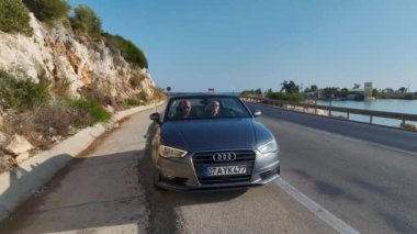 Akdeniz 'in masmavi suları boyunca üstü açık bir arabada huzurlu bir yolculuğun tadını çıkarın..