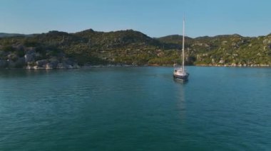 Rıhtıma yanaşmış yatları ve yelkenlileri olan küçük bir köyü izle..