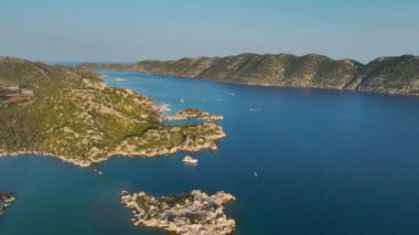 Rıhtımda yatları ve yelkenlileri olan deniz kenarındaki küçük bir köyün keyfini çıkarın..