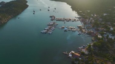 Yat ve yelkenli dolu küçük bir turist köyünün sıcacık rıhtımına bakın..