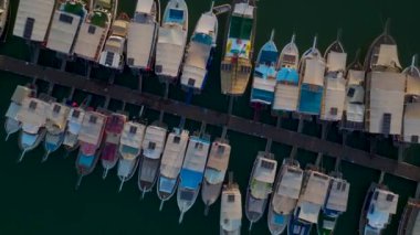 Yat ve yelkenli dolu bir rıhtımı olan huzurlu köyü izle..