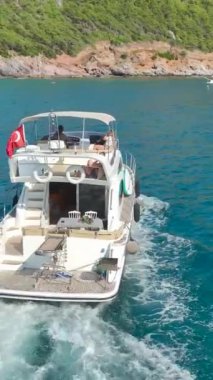 Bu büyüleyici dikey videoda denizdeki yatlarla nefes kesici bir Akdeniz manzarasına tanık olun..