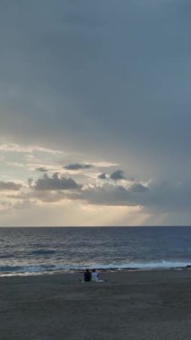 Akdeniz üzerindeki bulutlu günbatımının büyüleyici güzelliğine dikey bir şekilde bakın..