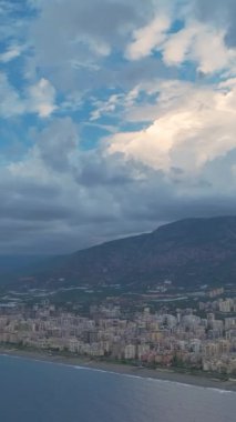 Dikey biçimde bulutlu bir günbatımının hızlandırılmış renkleriyle çizilen ufuk çizgisini izle.