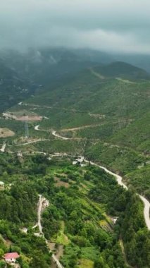 Yağmurlu bir günde, bir dağ köyünün büyüleyici cazibesini dikey bir hava perspektifinden keşfedin..