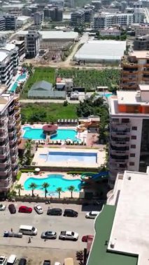 Yeni yerleşim tesislerinin sakinliğini keşfedin. Havuz kenarındaki güzelliği, nefes kesen havadan dikey görüntüler aracılığıyla keşfedin..