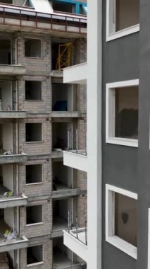İnşaat halindeki evlerin, pencerelerin ve cephe yerleşimlerinin dikey formatında hava perspektifini elde edin.