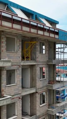 Pencerelerin ve cephe elementlerinin ev inşaatının son aşamalarına dikey biçimde titizlikle yerleştirilmesini izleyin.