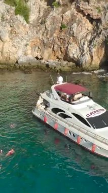 Bu dikey videoda büyüleyici gök mavisi denizde yelken açan yatları gösteren havadan Akdeniz büyüsüne tanık olun..