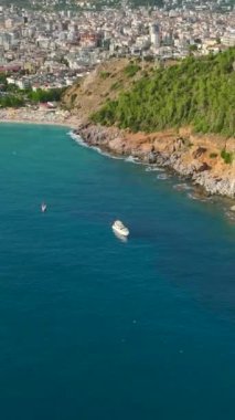 Bu dikey videoda, huzurlu gök mavisi sularda sürüklenen beyaz yelkenlilerin hava manzaralı bir görüntüsüyle, sakin bir yelkenli bulun..