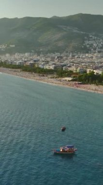 Bu dikey videoda büyüleyici gök mavisi sularda seyreden yatların havadan görüntüsüyle sahile kaçacağız..