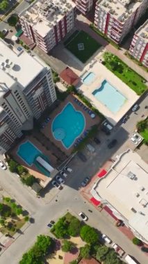 Bu dikey videoda büyüleyici bir gök mavisi havuzu olan Akdeniz tarafından lüks bir konut kompleksinin zarafetini keşfedin..