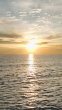 4K 'daki alacakaranlığı kucaklayın. Hava manzaralı. Bu dikey videoda deniz üzerinde gün batımını yakalayın..