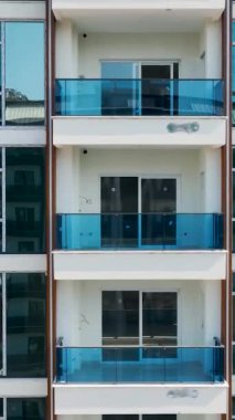 Bu dikey videoda bina sürecini yüksek görünüm, ön cepheleri, balkonları ve pencere kurulumlarını göster.