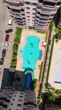 Bu dikey videoda elit bir yerleşim yerindeki gökyüzü havuzunun çarpıcı 4K hava manzaralı mutluluğunu tecrübe edin..