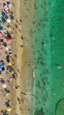 4K 'da bir kıyı cenneti keşfedin. Gök mavisi güzel Akdeniz' de yüzen insanların havadan görüntüsü olsun..
