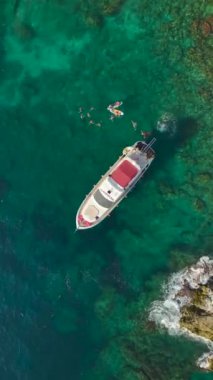 4K 'daki zarafeti, bu dikey videoda mavi denizde lüks beyaz bir yat yelken açarken tecrübe edin..