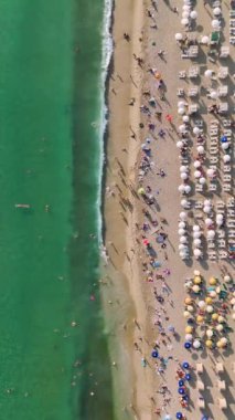 Bu dikey videoda Akdeniz 'in masmavi sularında yüzen insanların 4K' daki deniz kıyısında keyifli anlarında.