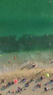 4K 'deki bir sahil cennetine kaçın. Bu dikey videoda insanların yaz tatillerinin tadını çıkardıkları gökyüzü manzaralı bir yere..