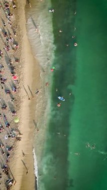 4K 'da deniz kenarındaki huzurlu anları yakalayın. Gök mavisi sularda yaz tatillerinin tadını çıkaran insanların havadan görüntüleriyle..