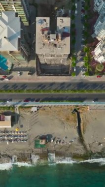 Ufuk çizgisini ilk sahil şeridinde evleri olan 4K 'da keşfedin. Rüya gibi kıyı gelişimini yakalayan dikey bir video.