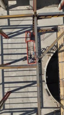 Mega AVM yükselirken 4K 'de bir alışveriş merkezine adım atın. Metal yapıların kurulumunun dikey bir videosu.